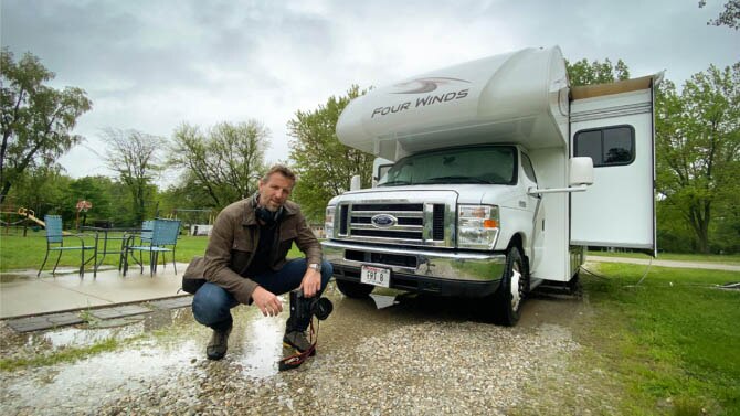 Mikey Kay kneeling in front of an RV