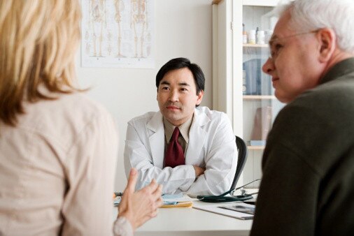 Clinician in a white coat discussing Smart Technology with a couple