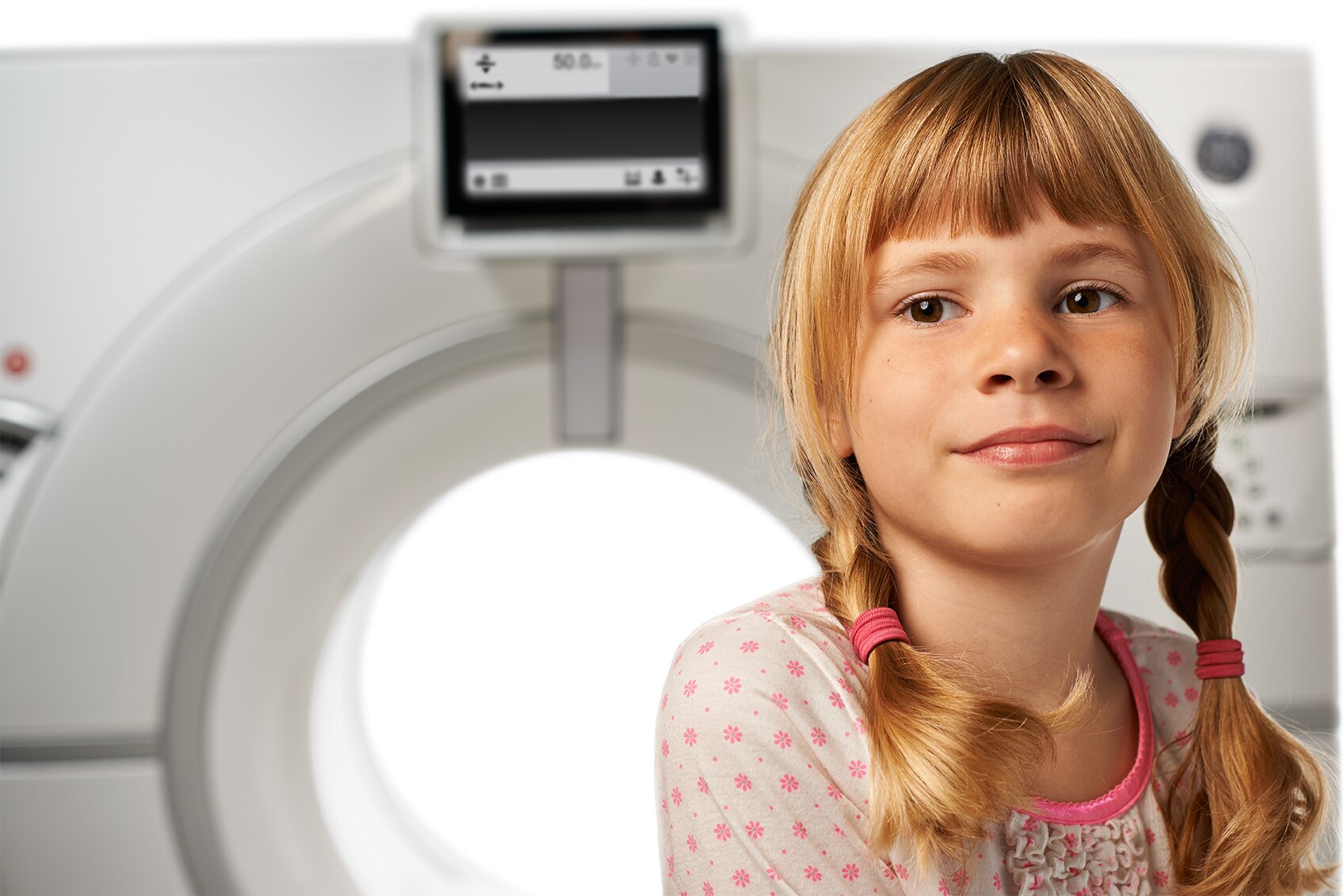 Young girl sitting on Revolution CT machine